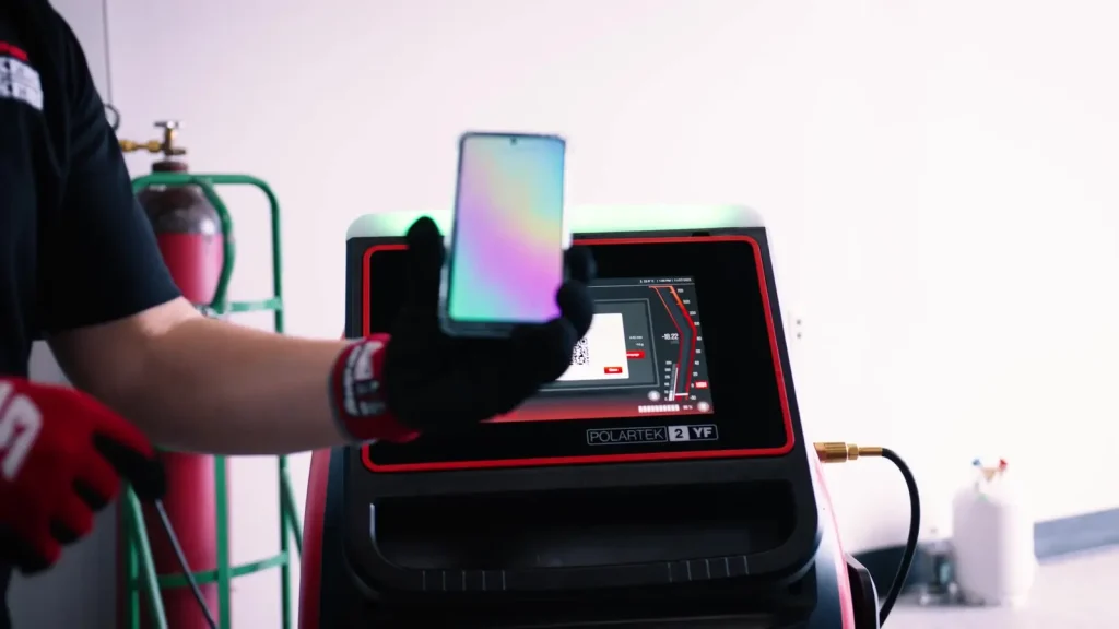 Technician using the Snap-on PolarTek R-1234yf machine during AC leak detection